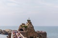 Local landmark cliff with statue of Virgin Mary on top and beautiful view of endless sea. Biarritz city